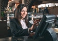 Small business, people and service concept - happy woman or waiter or manager in apron at counter with cashbox working Royalty Free Stock Photo