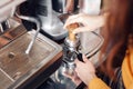 Small business, people and service concept - woman or waiter in apron with holder and tamper preparing coffee at coffee