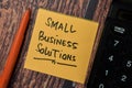 Small Business Solutions write on sticky notes isolated on office desk Royalty Free Stock Photo