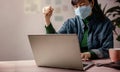 Small Business and Successful during Coronavirus Concept. blurred Gladful Business Woman wearing Mask, Working on Computer Laptop