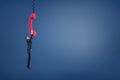 A small businessman holds a giant red retro phone handle and hangs from it trying not to fall. Royalty Free Stock Photo