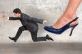 Small businessman running away from a boss pressure Royalty Free Stock Photo