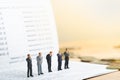 Small businessmans figures standing on turning point on bank passbook. Royalty Free Stock Photo