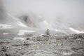 Small Cairn, Pile of Stone on Sella, Sass Pordoi, in the Dolomites with a bright Foggy background. Royalty Free Stock Photo