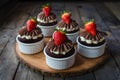 Small cakes topped with chocolate frosting and strawberries, complimentary