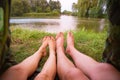 A small camping tent on the lake, a night`s lodging and the feet of a young couple Royalty Free Stock Photo