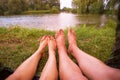 A small camping tent on the lake, a night`s lodging and the feet of a young couple Royalty Free Stock Photo