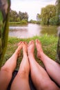 A small camping tent on the lake, a night`s lodging and the feet of a young couple Royalty Free Stock Photo