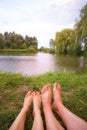 A small camping tent on the lake, a night`s lodging and the feet of a young couple Royalty Free Stock Photo