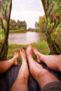 A small camping tent on the lake, a night`s lodging and the feet of a young couple Royalty Free Stock Photo