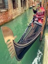 Small canal with parked gondola in Venice, Italy