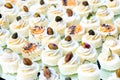 Small canapes with fish cream, pistachios and poppy seeds. Catering fingerfood for wedding. Diagonal composition. White Royalty Free Stock Photo