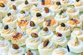 Small canapes with fish cream, pistachios and poppy seeds. Catering fingerfood for wedding. Diagonal composition. White Royalty Free Stock Photo