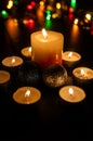 Small candles around a bigger candle and two Christmas globes Royalty Free Stock Photo