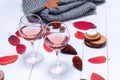 Small candles, two glasses with rose wine, cones, dry red leaves, gray scarf knitted on a white wooden table. Royalty Free Stock Photo