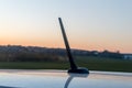 Small car antenna on the roof. Radio antenna with sunset background Royalty Free Stock Photo