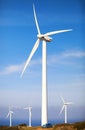 Small car on a wind turbines farm Royalty Free Stock Photo