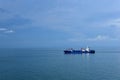 Small cargo container ship sailing through calm, blue sea. Royalty Free Stock Photo