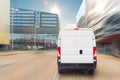 Small cargo delivery van driving in european city central district. Medium lorry minivan courier vehicle deliver package at