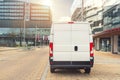 Small cargo delivery van driving in european city central district. Medium lorry minivan courier vehicle deliver package at