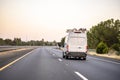 Small cargo mini van with ladder on the roof driving on the road to point of the service Royalty Free Stock Photo