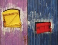 Small Caribbean style doors. Yellow and Intense Red. Rusty. Yellow, blue and pink worn sheets