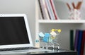 Small cart with paper bags and laptop on glass table. Online shopping Royalty Free Stock Photo