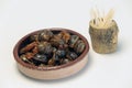 small casserole of snails in sauce and some chopsticks Royalty Free Stock Photo