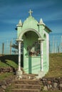 Small Catholic shrine amid a rural landscape