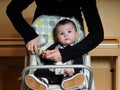 Small caucasian baby boy sitting in chear with notepad