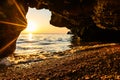 A small cave by the sea during sunset.