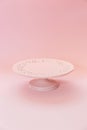Small ceramic empty pink pedestal cake stand on a pastel pink table Royalty Free Stock Photo