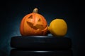 Halloween composition with ceramic Jack Lantern pumpkins and gym dumbbells.