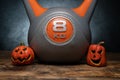 Halloween composition with ceramic Jack Lantern pumpkins and gym kettlebell. Royalty Free Stock Photo