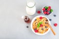 Small cereal pancakes with maple syrup, raspberry, blueberry and milk, in white bowl, horizontal, top view, copy space Royalty Free Stock Photo