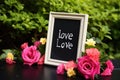 a small chalkboard with a love message surrounded by flowers