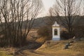 Small chapel by the road in the fields in a late winter landscape