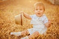 Small charming chubby little boy in a white suit holding a hat , Royalty Free Stock Photo