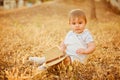 Small charming chubby little boy in a white suit holding a hat , Royalty Free Stock Photo