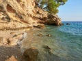 A small, charming pebble beach hidden under a cliff in the Croatian town of Brela. A cove on the shores of the Adriatic sea.