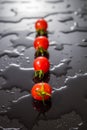 Small cherry tomato on a black background with water Royalty Free Stock Photo