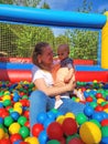 Baby girl lying down in colourful balls with mother