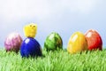 Small chicked on Painted easter egg, grass and blue background Royalty Free Stock Photo