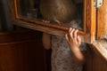 A small child is afraid of punishment and hides behind a window frame Royalty Free Stock Photo