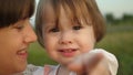 Small child in arms of her sister smiles and shows her finger in camera, family walk in park in the summer, slow-motion Royalty Free Stock Photo