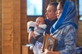 A small child at a baby christening ceremony in a church. the godfather holds a little boy in his arms. Baptism of a