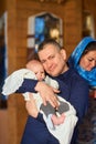 A small child at a baby christening ceremony in a church. the godfather holds a little boy in his arms. Baptism of a