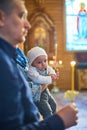 A small child at a baby christening ceremony in a church. the godfather holds a little boy in his arms. Baptism of a