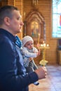 A small child at a baby christening ceremony in a church. the godfather holds a little boy in his arms. Baptism of a