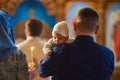 A small child at a baby christening ceremony in a church. the godfather holds a little boy in his arms. Baptism of a